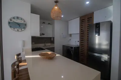 a kitchen with a white counter and a clock on the wall at Hermoso apartamento con vista al mar in Cartagena de Indias