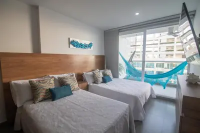 a hotel room with two beds and a window at Hermoso apartamento con vista al mar in Cartagena de Indias