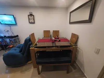 a dining room table with a blue chair and a desk at Apartamento Cartagena - Terrazas de Calicanto in Cartagena de Indias
