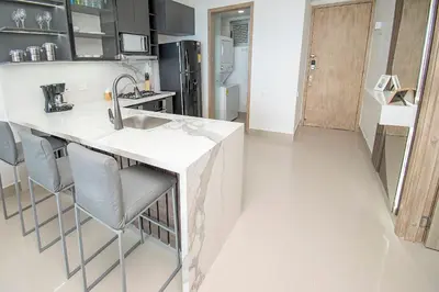 a kitchen with a sink and a counter with chairs at U-GO Palmetto Eliptic - Confort y Estilo en Cartagena in Cartagena de Indias