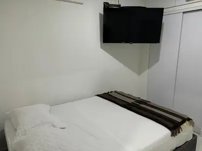a bedroom with a bed with a television on the wall at Tropical Caribean Apartment in Cartagena de Indias