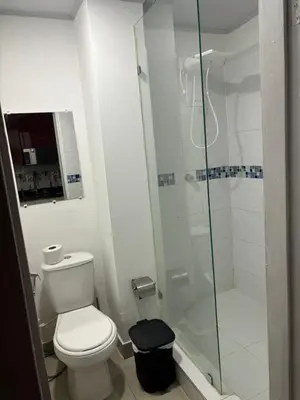 a bathroom with a toilet and a glass shower at Tropical Caribean Apartment in Cartagena de Indias