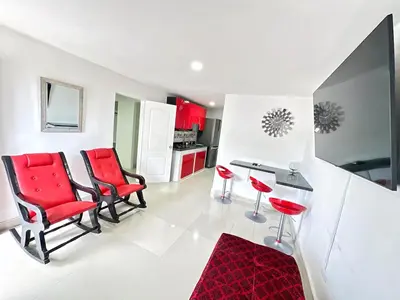 a kitchen with red chairs and a red rug at Tropical Caribean Apartment in Cartagena de Indias