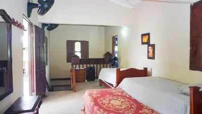 a bedroom with a bed and a desk in a room at Cabaña Villa Palmaral in Moñitos