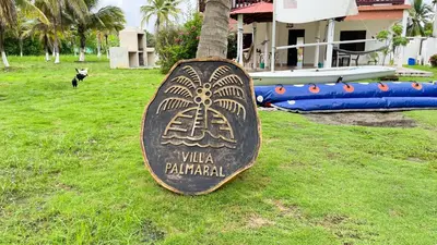 a sign that says villa balimendi on a tree at Cabaña Villa Palmaral in Moñitos