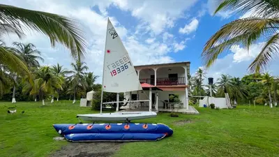 a small sail boat on a raft in front of a house at Cabaña Villa Palmaral in Moñitos