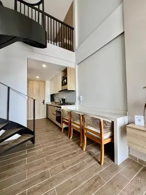 a living room with a staircase and wooden chairs at Beautiful! Brand New Apt old town in Cartagena de Indias