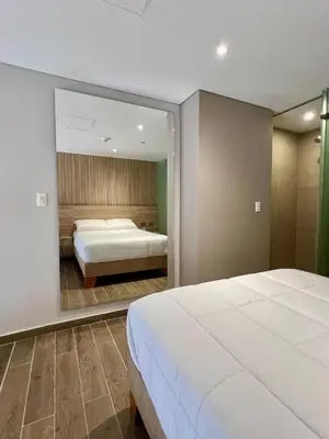 a bedroom with a large white bed and a mirror at Beautiful! Brand New Apt old town in Cartagena de Indias