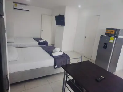 a small room with two beds and a refrigerator at Marina del rey propiedades gaitan in Cartagena de Indias