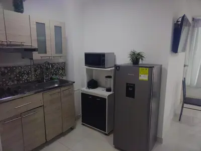 a small kitchen with a refrigerator and a microwave at Marina del rey propiedades gaitan in Cartagena de Indias