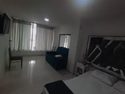 a bedroom with a bed and a chair and a couch at Marina del rey propiedades gaitan in Cartagena de Indias