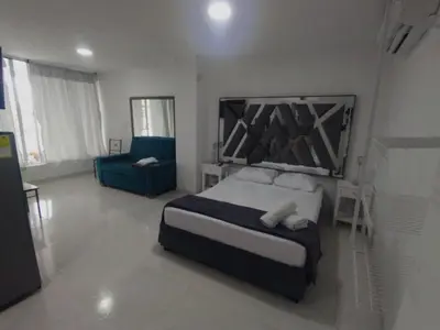 a bedroom with a bed and a blue couch at Marina del rey propiedades gaitan in Cartagena de Indias
