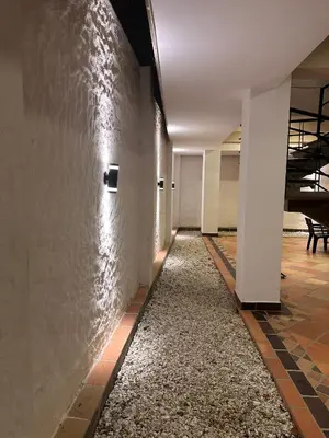 an empty hallway in an office building with a stone wall at Santa Donama Paradise in Santa Marta