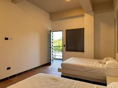 a bedroom with two beds and a door to a balcony at Santa Donama Paradise in Santa Marta