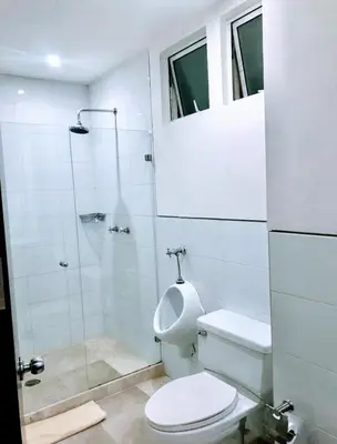 a white bathroom with a toilet and a shower at Apartamento con vista frontal al mar. in Cartagena de Indias