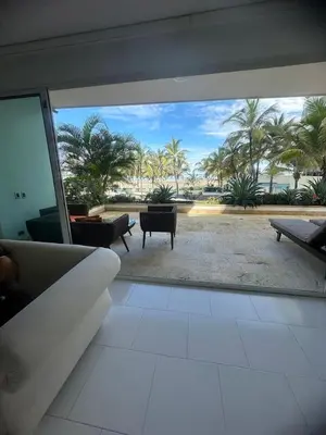 a living room with a view of a patio with palm trees at Apartamento con vista frontal al mar. in Cartagena de Indias