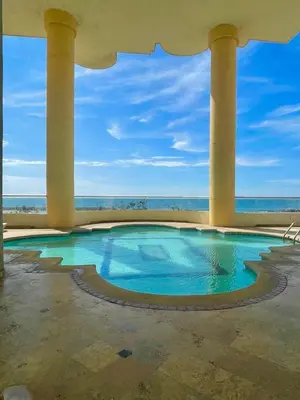 a swimming pool with columns and the ocean in the background at Cabrero Beach 906 in Cartagena de Indias