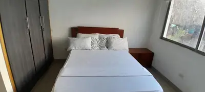 a small bedroom with a bed with white sheets and pillows at TOLU ALOJAMIENTOS Oasis tropical elegante, relax, apartamento amoblado in San Silvestre