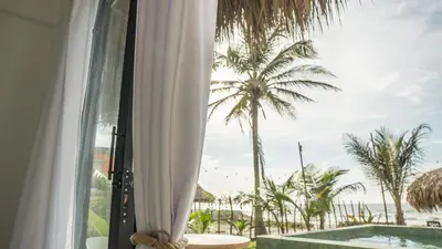 a view of a palm tree from a window at Cosamui Beach House in San Bernardo del Viento
