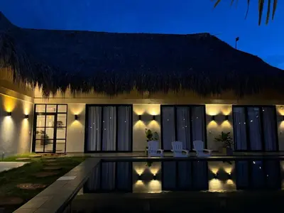 a villa with a swimming pool at night at Cosamui Beach House in San Bernardo del Viento