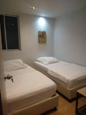 two twin beds in a room with a window at Confortable apto en Coveñas in Coveñas