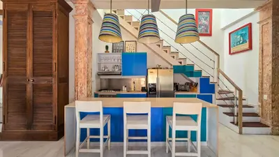 a kitchen with blue and white cabinets and stairs at Casa Lazuli 303 Cartagena in Cartagena de Indias
