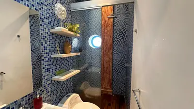 a bathroom with a toilet and a shower with blue tiles at Casa Lazuli 303 Cartagena in Cartagena de Indias