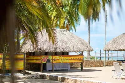a restaurant with a table and a straw umbrella on the beach at Coveñas - Condominio Puntepiedra Hotel in Coveñas