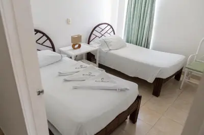 a room with two beds and a table at Coveñas - Condominio Puntepiedra Hotel in Coveñas