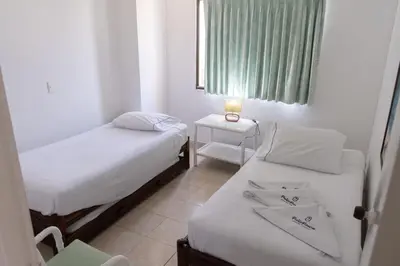 a small room with two beds and a window at Coveñas - Condominio Puntepiedra Hotel in Coveñas