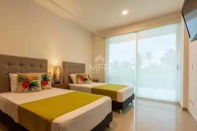 a bedroom with two beds and a large window at Morros Vitri Beachfront & 2 Bedrooms in Cartagena de Indias