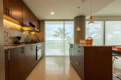 a kitchen with wooden cabinets and a large window at Morros Vitri Beachfront & 2 Bedrooms in Cartagena de Indias
