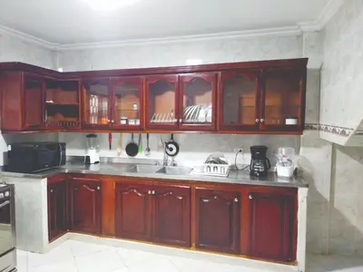 a kitchen with wooden cabinets and a sink at Hostal Renacer in Cartagena de Indias