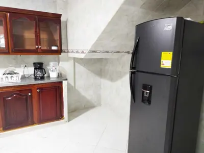 a kitchen with a black refrigerator in a room at Hostal Renacer in Cartagena de Indias