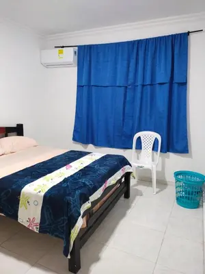 a bedroom with a bed and a blue curtain at Hostal Renacer in Cartagena de Indias