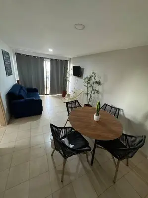 a living room with a table and chairs and a couch at Apartamento frente a la playa in Cartagena de Indias