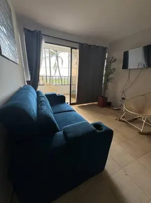 a living room with a blue couch and a television at Apartamento frente a la playa in Cartagena de Indias