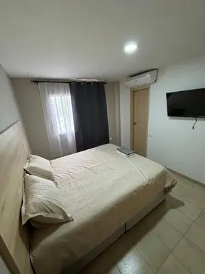 a bedroom with a bed and a television in it at Apartamento frente a la playa in Cartagena de Indias