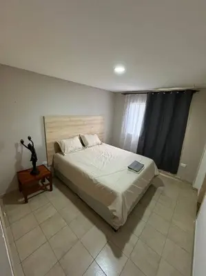 a bedroom with a bed and a table and a window at Apartamento frente a la playa in Cartagena de Indias