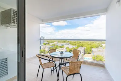 a table and chairs on a balcony with a view at Lujoso Apartamento Cartagena - 2 mins aeropuerto in Cartagena de Indias