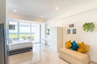 a bedroom with a bed and a couch in a room at Lujoso Apartamento Cartagena - 2 mins aeropuerto in Cartagena de Indias
