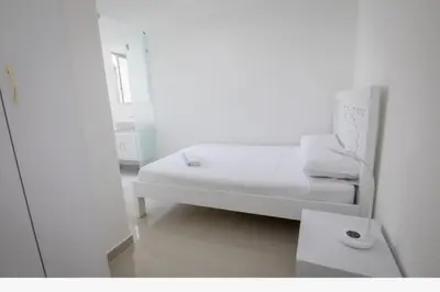 a white room with a bed and a table at Exclusivo Apartamento con vista al mar in Cartagena de Indias