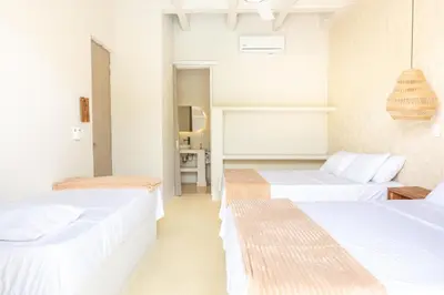 two beds in a room with white walls at Ilukas & Resort Villas in Coveñas