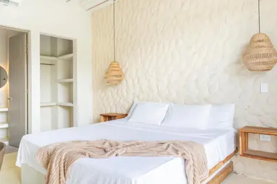 a bedroom with a bed and two pendant lights at Ilukas & Resort Villas in Coveñas