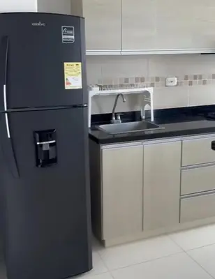 a kitchen with a black refrigerator and a sink at Apartamento en Coveñas in Coveñas