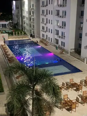 a swimming pool in the middle of a building with a palm tree at Apartamento en Coveñas in Coveñas