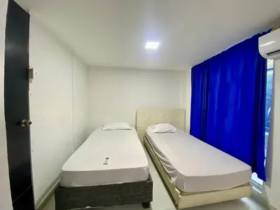 two beds in a room with a blue curtain at Casa Tranquila in Cartagena de Indias
