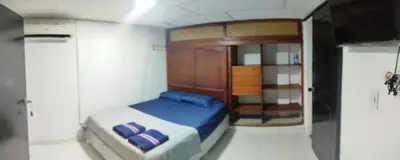 a small bedroom with a blue bed and a cabinet at Hermosa casa cerca de la playa in Cartagena de Indias