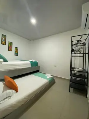 a bedroom with two beds and a shelf in it at Shekinah House in Cartagena de Indias
