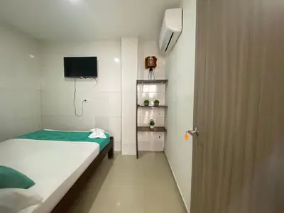 a small room with a bed and a television at Shekinah House in Cartagena de Indias